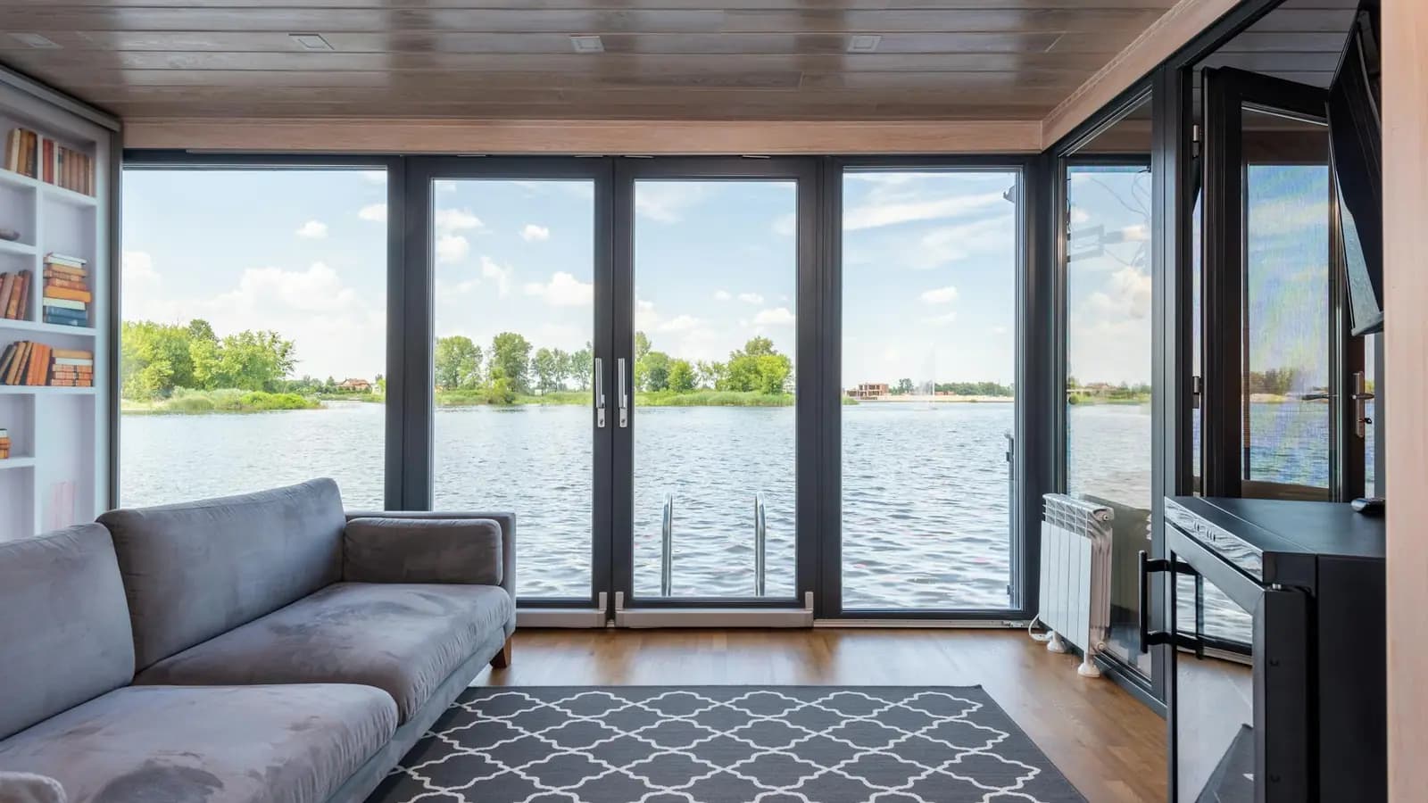 Floor-to-ceiling windows in a lake house living room with an open view of the water