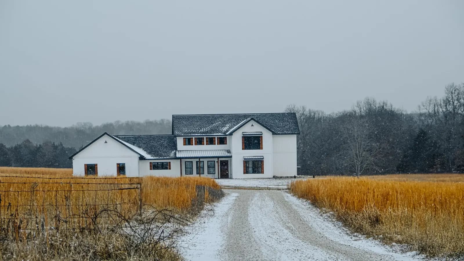 Modern farmhouse with white board-and-batten siding, dark-framed windows, and a standing-seam metal porch roof