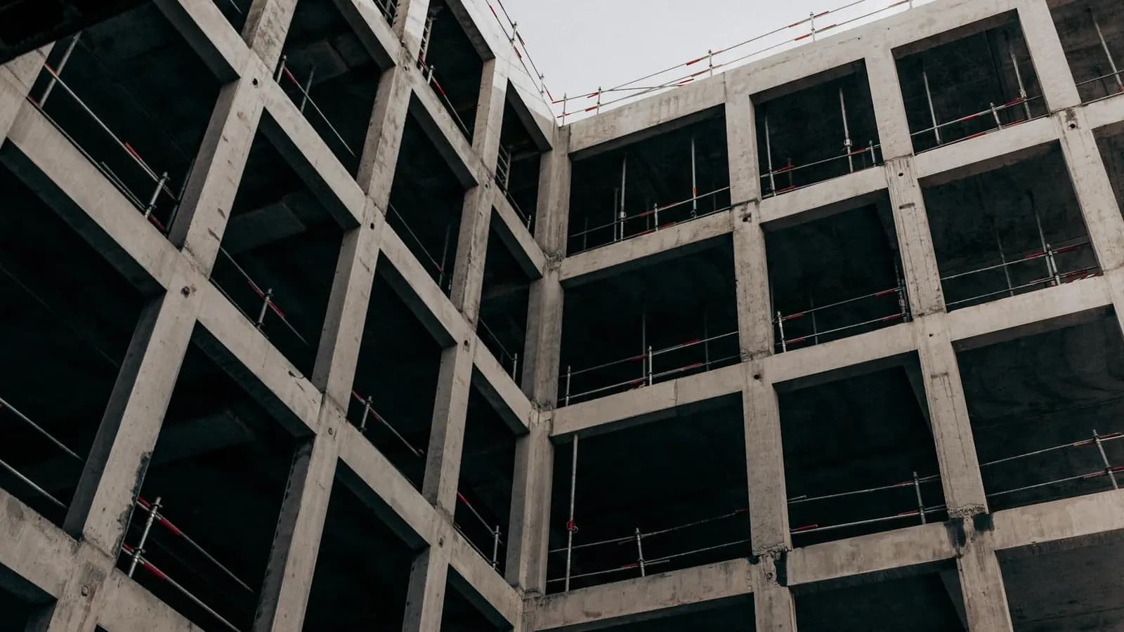Multi-story commercial building frame under construction with formwork and scaffolding